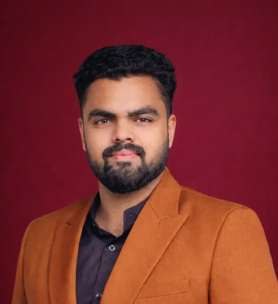Man in brown suit against backdrop