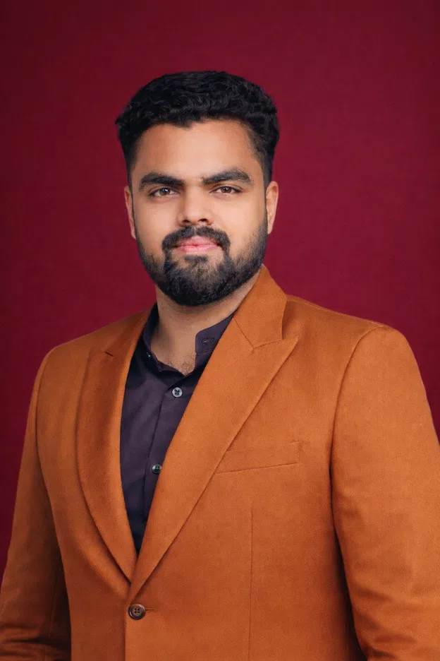 Man in brown suit against backdrop